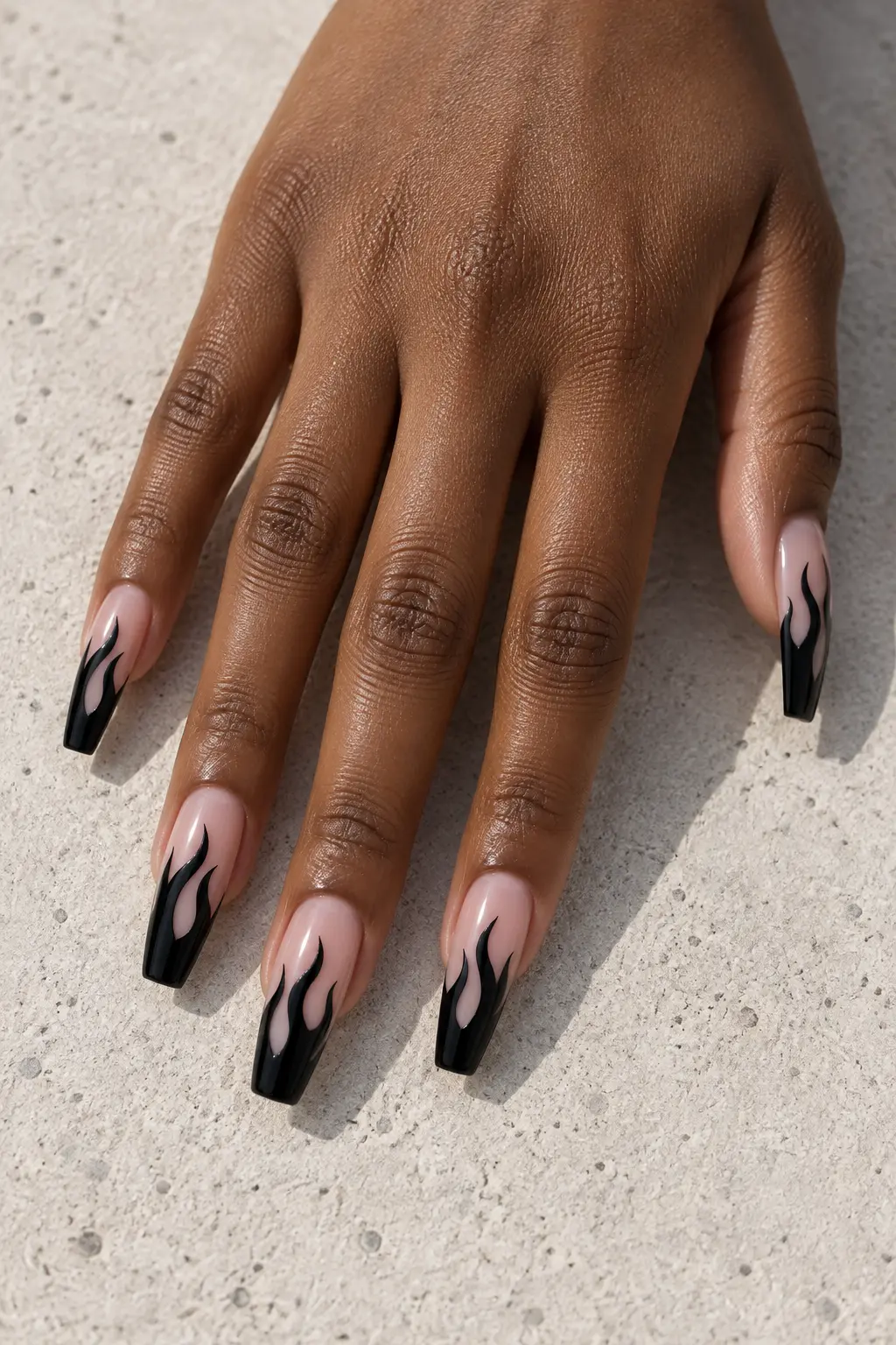 Sheer nude nails with glossy black flame tips