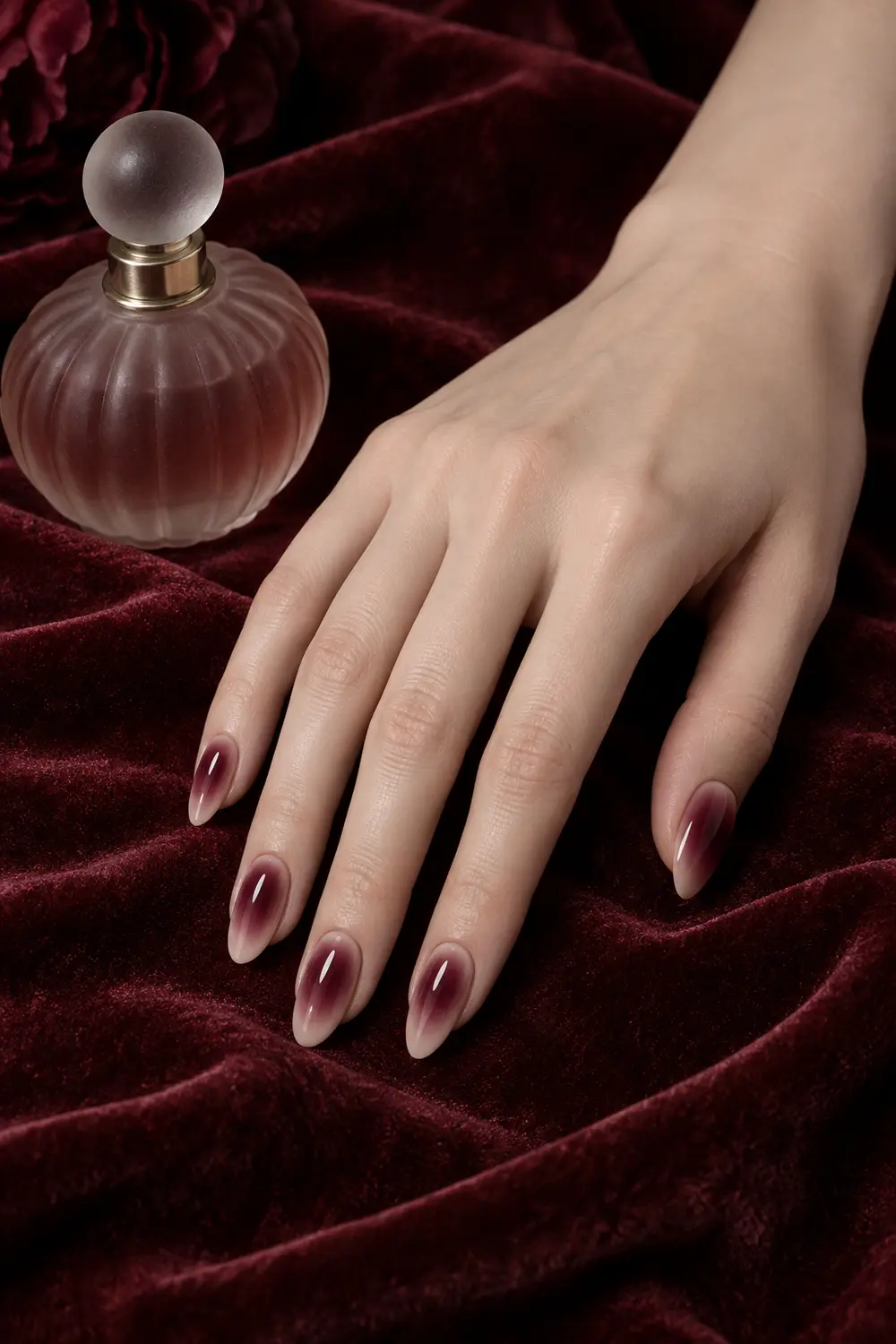 Glossy burgundy aura nails fading into sheer nude
