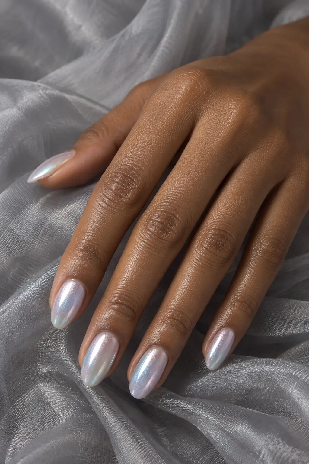 Milky pearl chrome nails with a faint icy blue shift