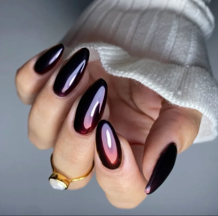 Long almond nails with a black base and a glowing cherry red chrome finish