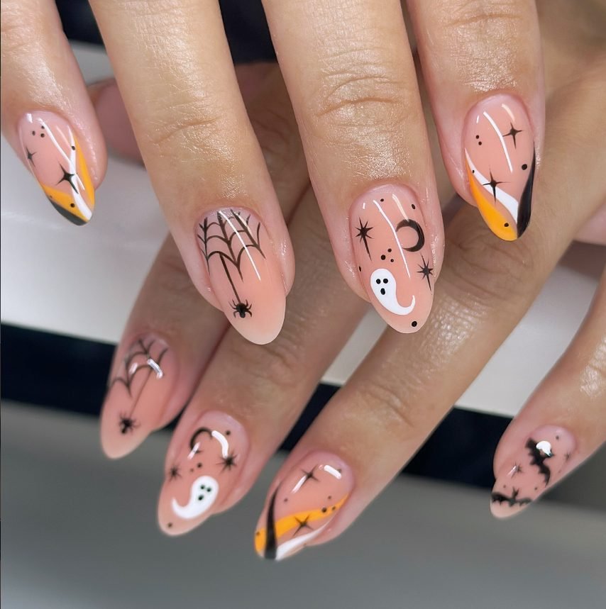 Peach nude almond nails with orange, white and black swirls, ghosts, spider webs, bats and stars