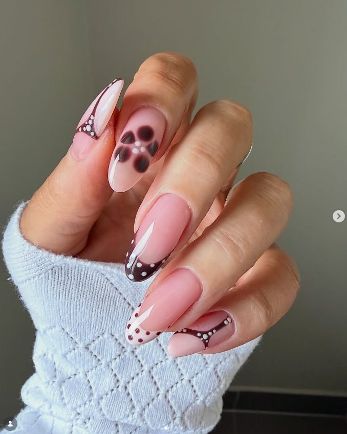 Long almond milky pink nails with chocolate burgundy French tips, white dot accents and blurry brown polka dots
