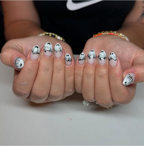 Short almond nails with white ghost French tips, black drip lines and black dot eyes