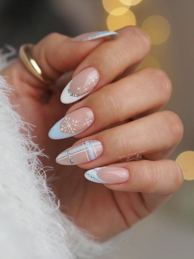 Nude almond nails with icy blue French tips, silver glitter lines, white snowflakes and blue plaid