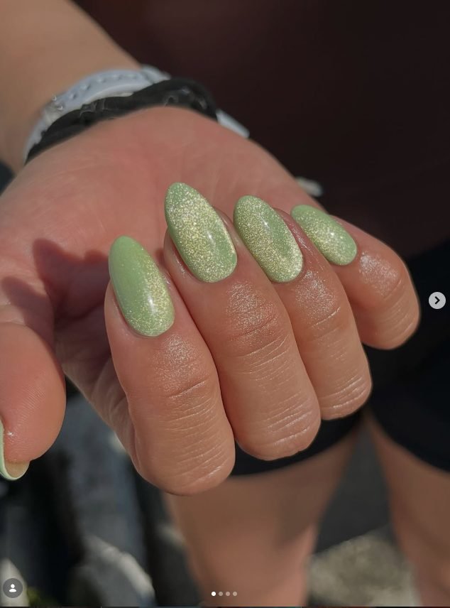 Oval nails in soft matcha green with a golden magnetic cat-eye sparkle