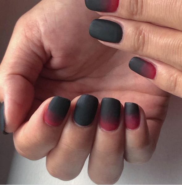 Short squoval nails with a matte black to red ombre fade for Halloween