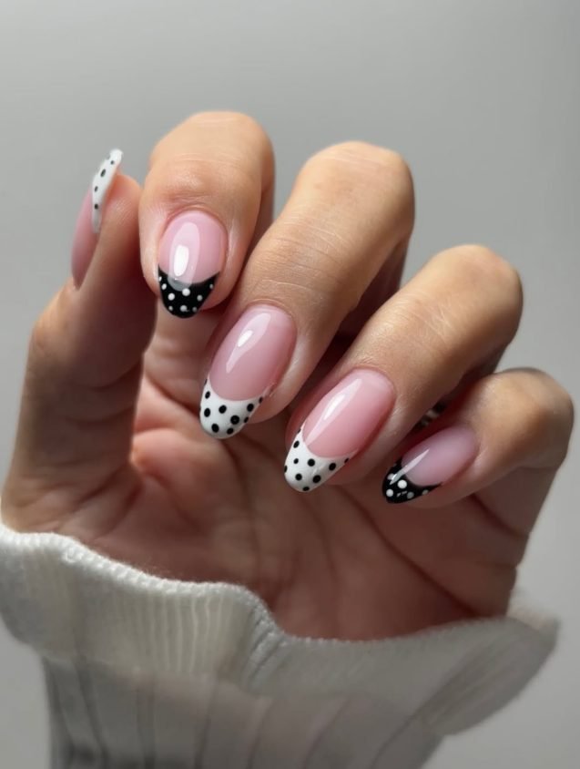 Pink almond nails with alternating black tips with white dots and white tips with black dots