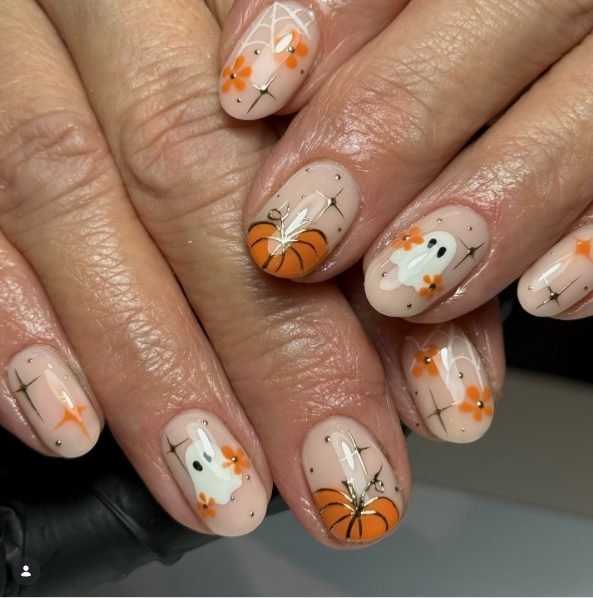 Short nude nails with orange pumpkins, white ghosts, orange flowers, spider webs and gold stars
