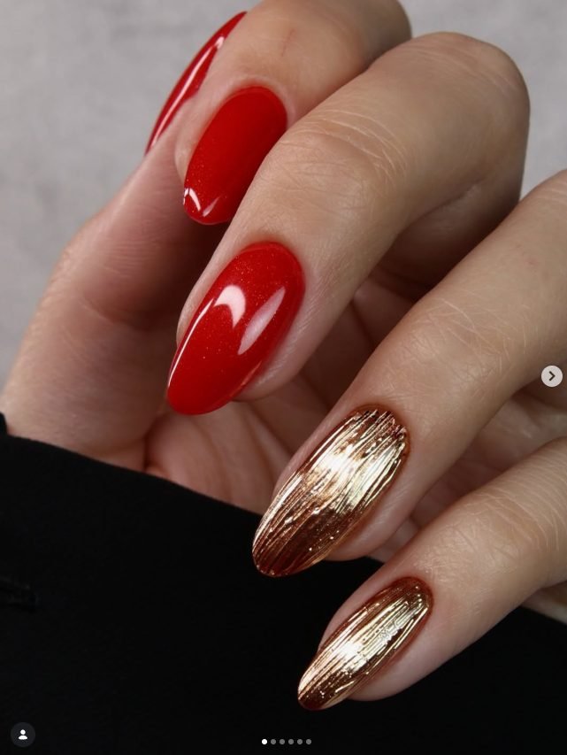 Almond nails in shimmering Christmas red with two nails in textured brushed gold chrome