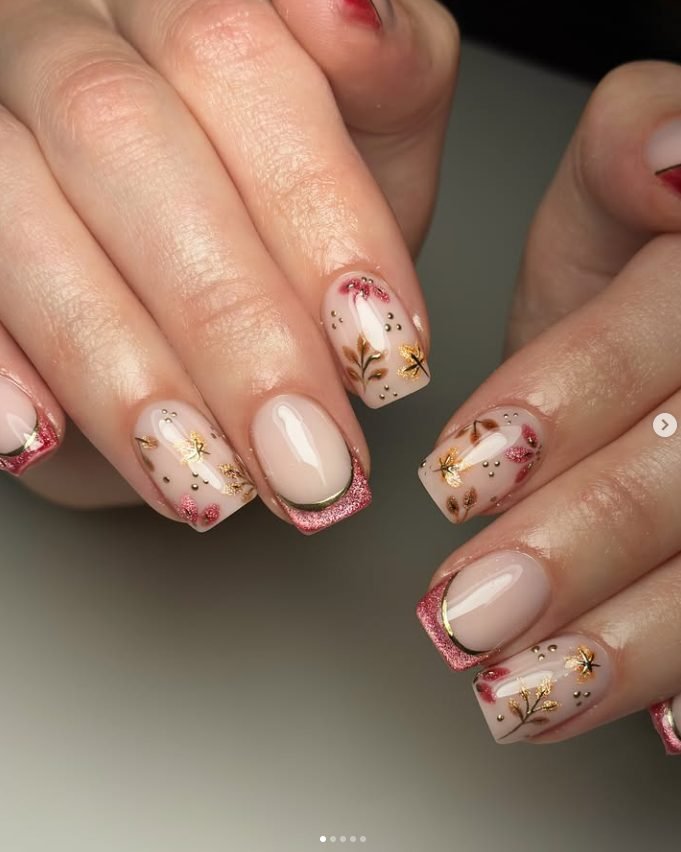 Square nude nails with rose pink glitter French tips edged in gold and hand-painted leaves and berries