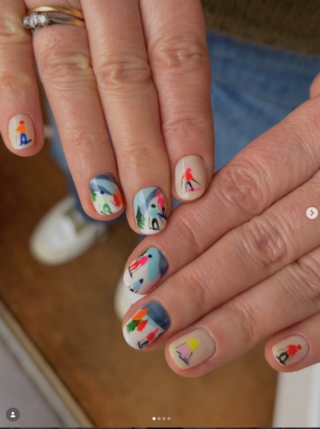 Short cream nails hand-painted with colorful skiers, mountains and pine trees