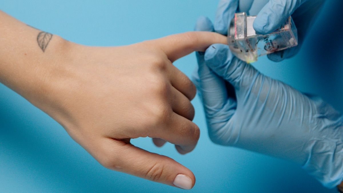 Close-up of a meticulous manicure with blue latex gloves applying nail polish.